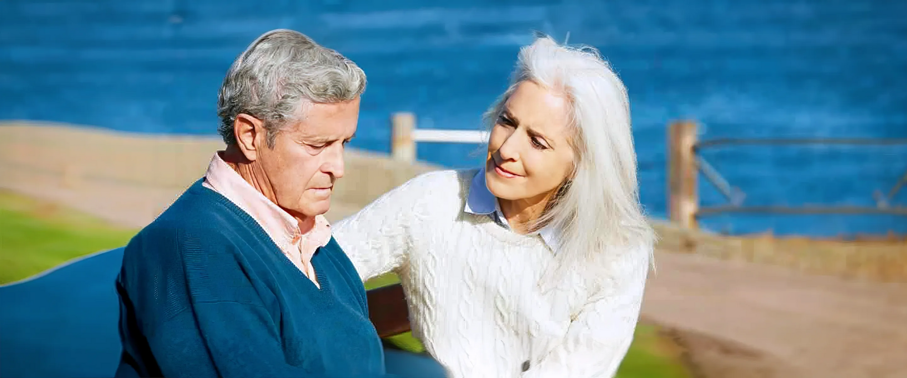 Senior-Woman Comforting Depressed Husband Sitting On Bench