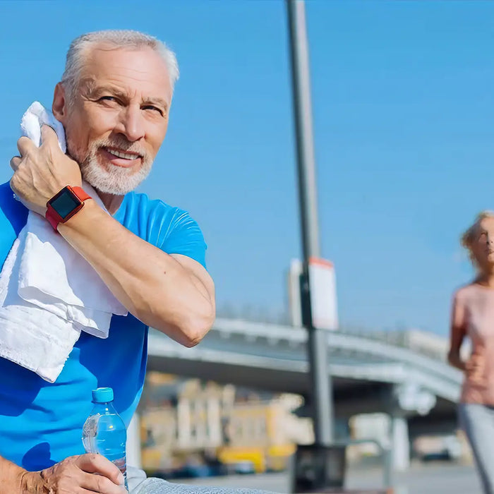 Senior man wiping sweat with towel after workout