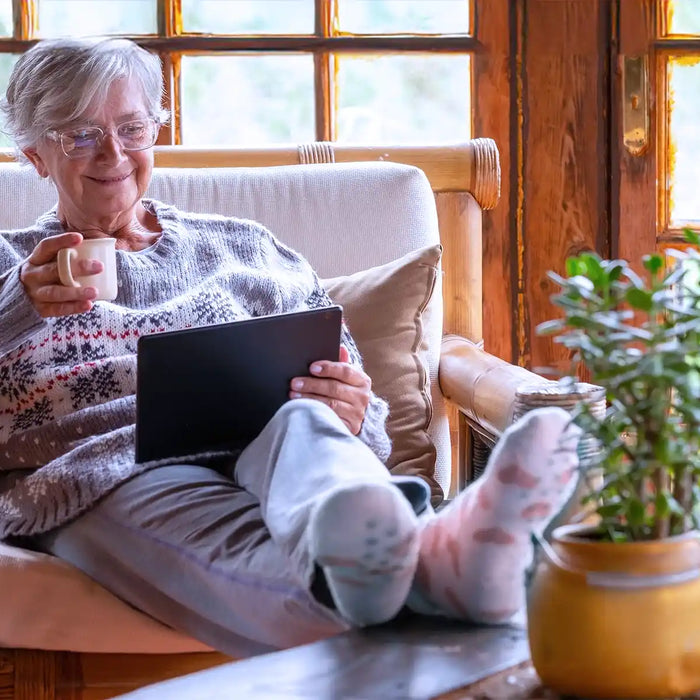 Smiling relaxed pensioner woman sitting at home