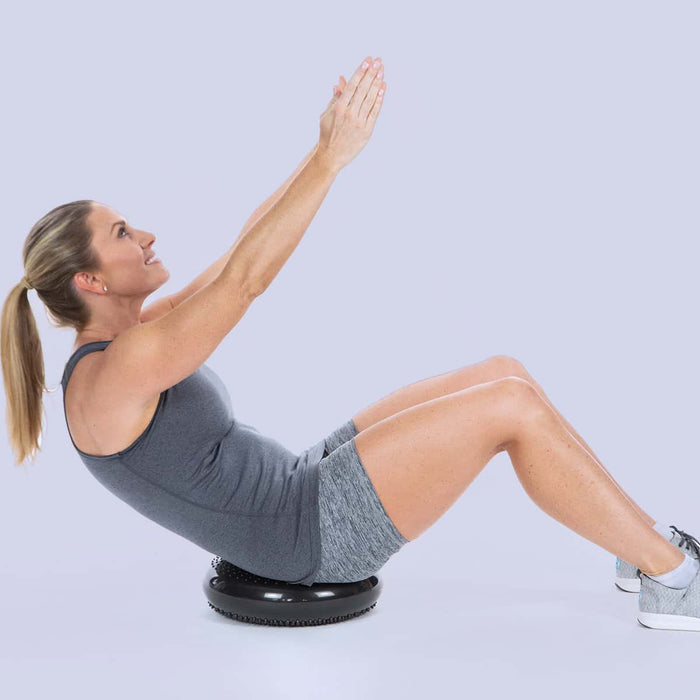 Woman doing a stretching pose on a wobble cushion